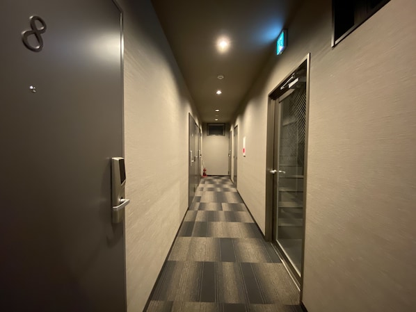 Stylish hotel corridor with checkered floor and modern doors.