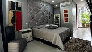 Une chambre à coucher moderne, avec un lit, une table de chevet, une chaise et une grande fenêtre.