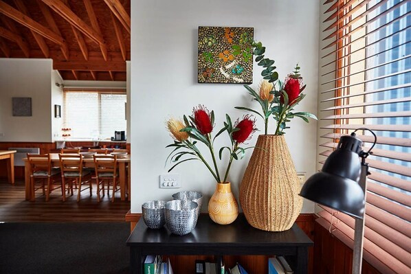 A dining area with wooden furniture, a table with decorative vases, and a painting on the wall.
