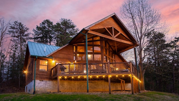 A wooden cabin with a balcony and string lights, surrounded by trees. - Mountain View Holy Smoky Cabin by RedAwning (Sevierville)