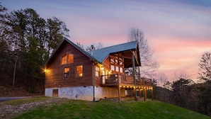 A wooden cabin with a balcony and string lights, surrounded by trees. - Mountain View Holy Smoky Cabin by RedAwning (Sevierville)