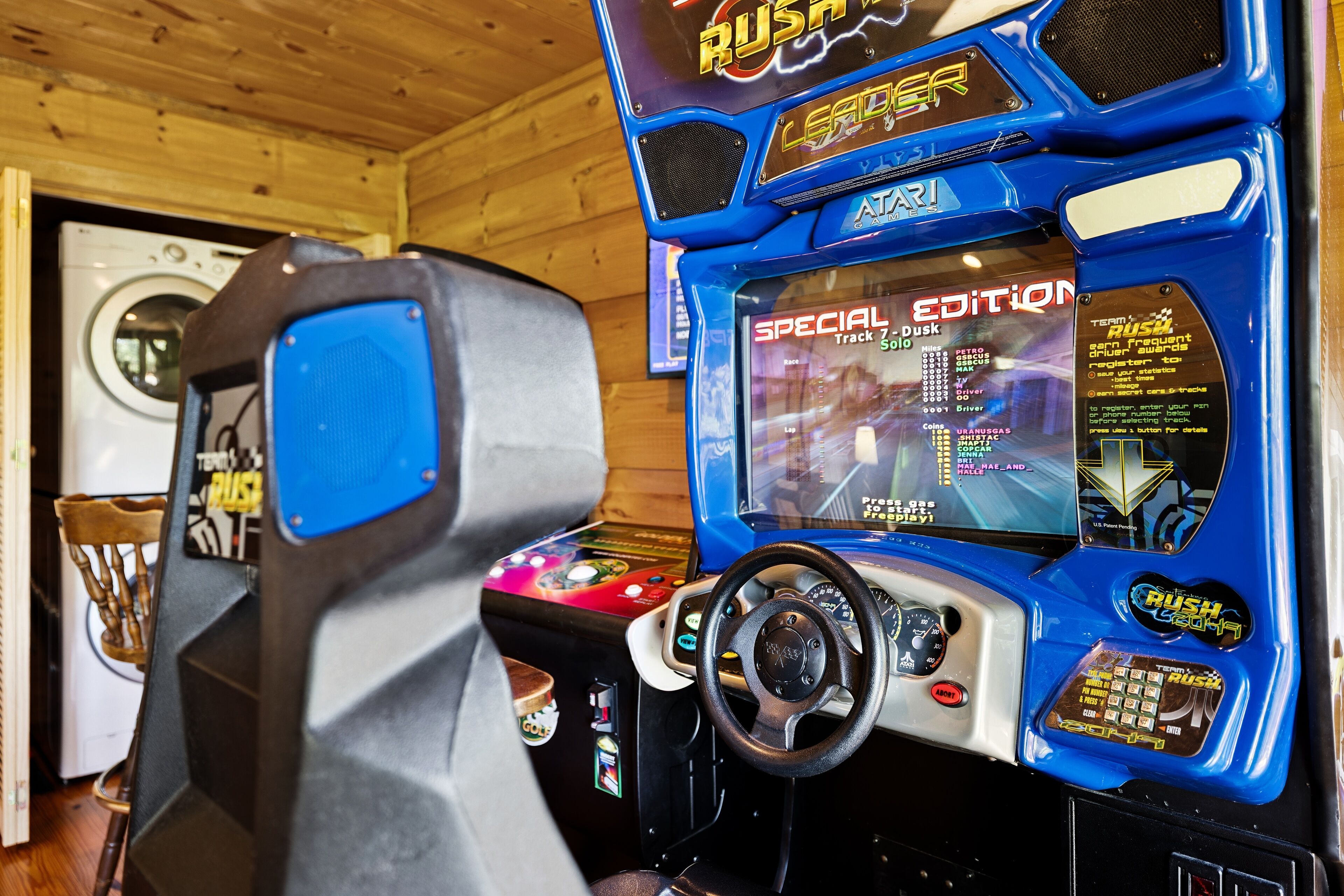 Máquina de arcade para jogo de corrida, com volante e tela exibindo um jogo de corrida.