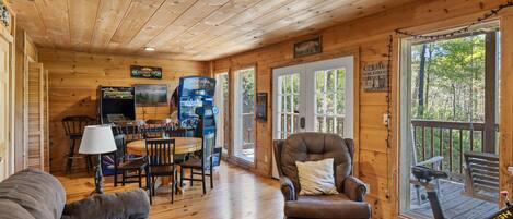 L’intérieur d’une cabine comprenant un coin repas, un canapé, un fauteuil et un tapis de course.