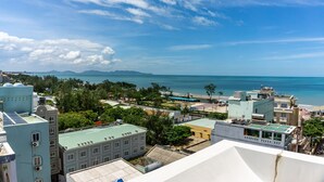 Un paisaje urbano costero con edificios, una playa y cielo despejado.