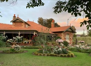 Una casa de dos pisos con techo de tejas y un porche cubierto.