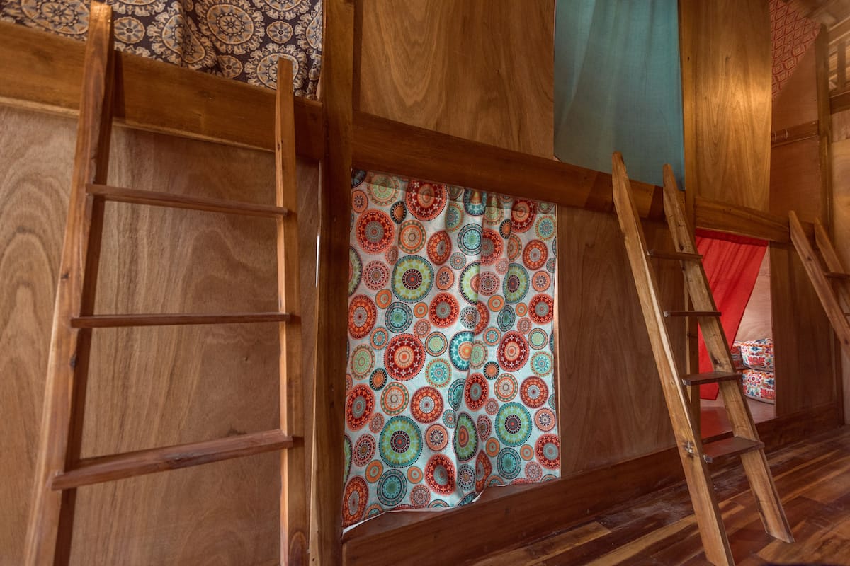 A wooden ladder leaning against a wall with a colorful circular pattern.
