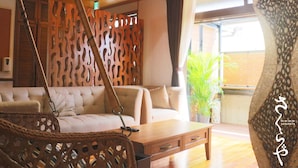 Un intérieur moderne avec un canapé, une table basse en bois et un fauteuil suspendu.