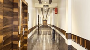 A long, polished hallway with a 'No Smoking' sign and a fire extinguisher.