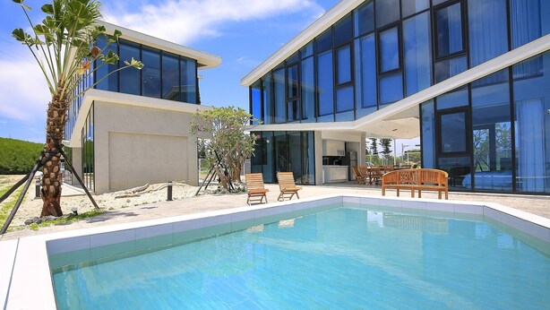 A modern building with a pool and outdoor seating.