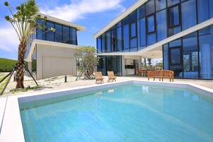 Un edificio moderno con piscina y zona de estar al aire libre.