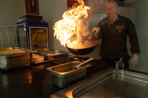 A chef cooking with flames in a kitchen. - The Nora Hotels Family Club (Alanya)