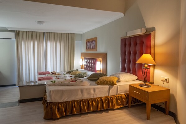 A hotel room with a bed, bedside table, and a lamp. - The Nora Hotels Family Club (Alanya)