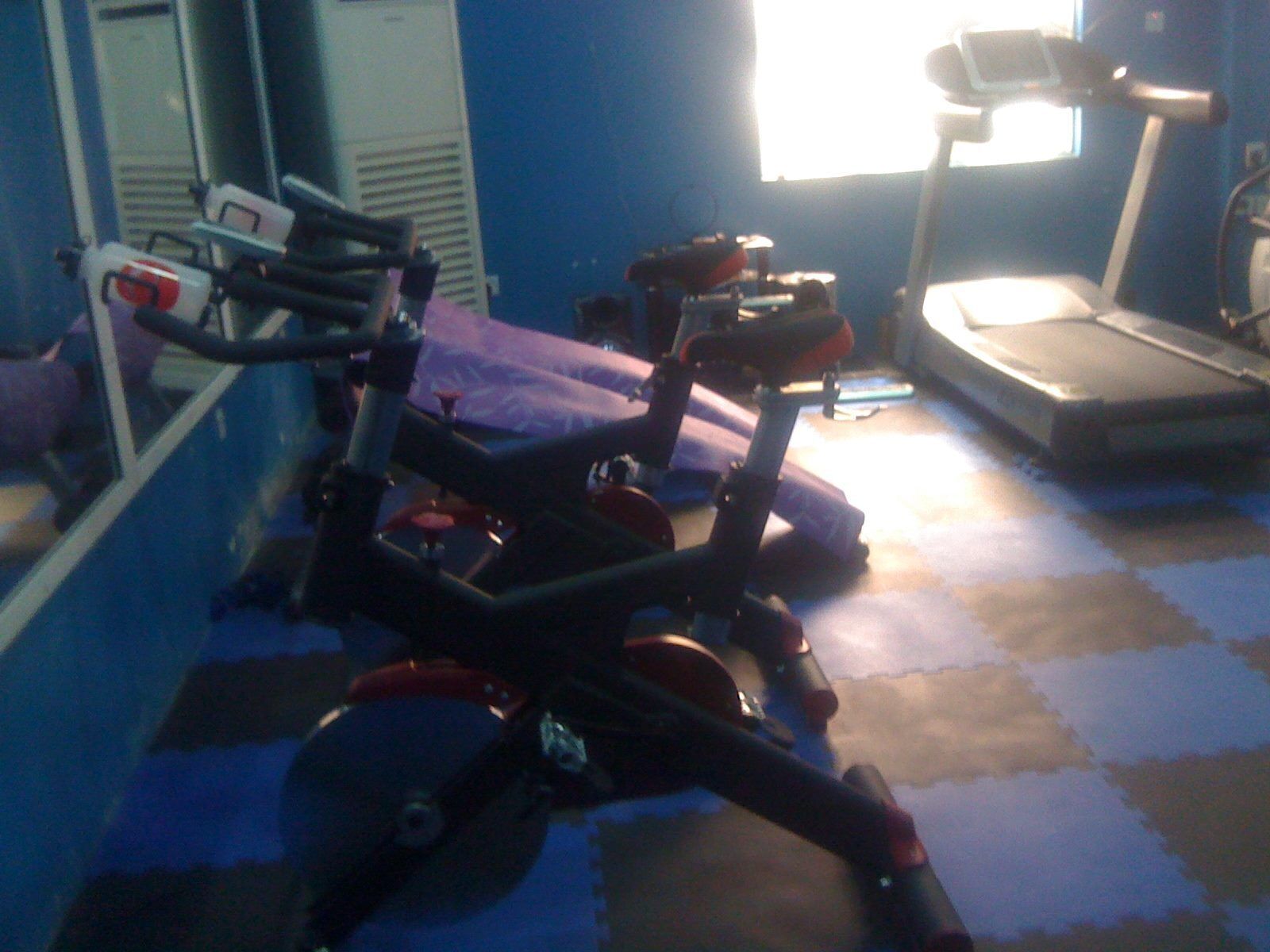 A gym with exercise equipment, including a stationary bike and a treadmill.
