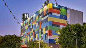 Un hotel de varios pisos con fachada colorida, numerosas ventanas y un letrero que indica que es un hotel.