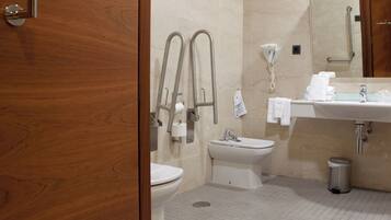 Een badkamer met toilet, bidet, wastafel en handdroger.