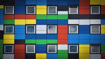 A building facade with multiple windows and a colorful pattern of squares.