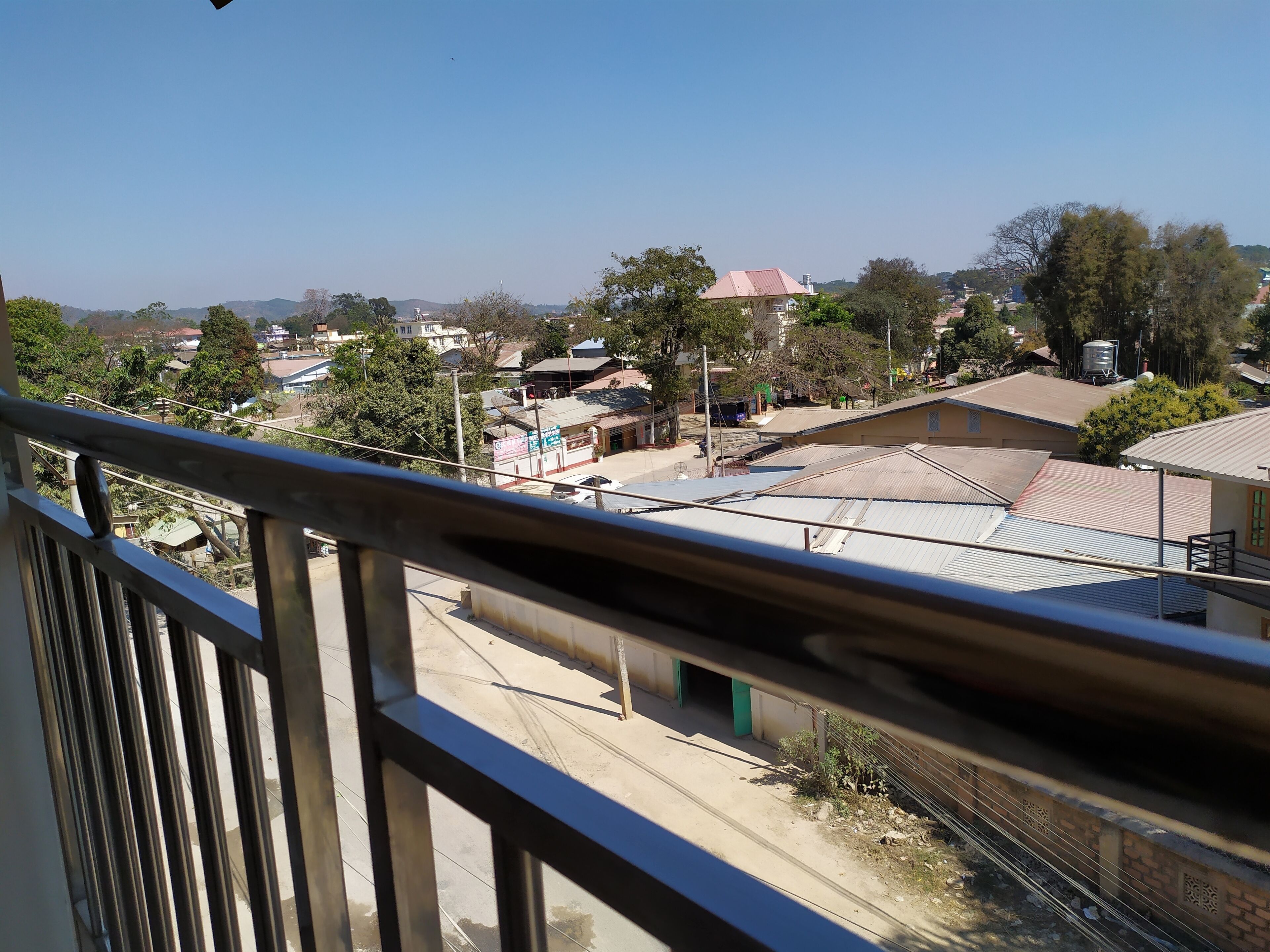 A residential area with houses, trees, and a clear sky.