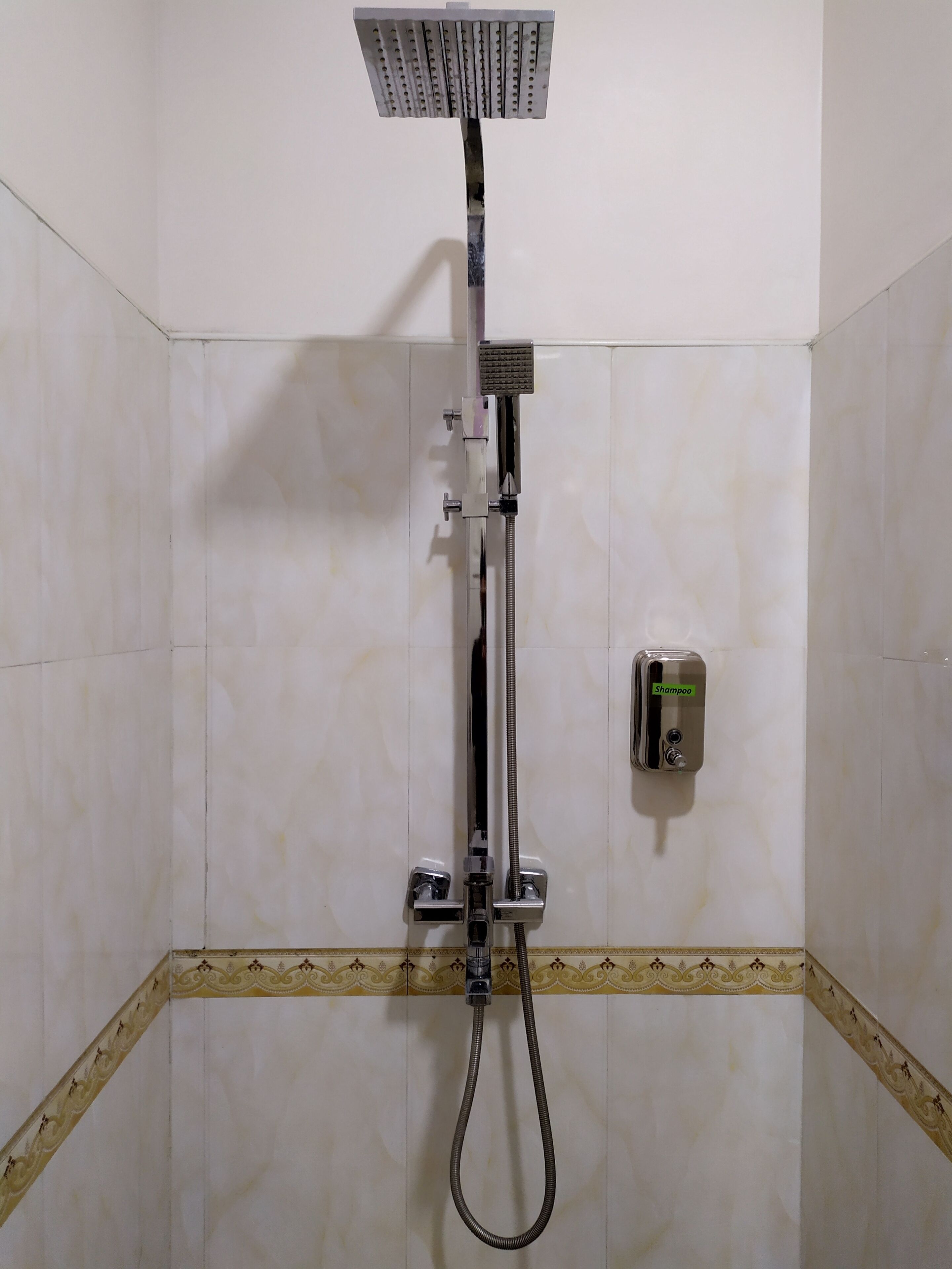 A shower with a handheld showerhead and a handheld shower attachment.
