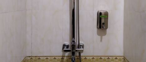 A shower with a handheld showerhead and a handheld shower attachment.