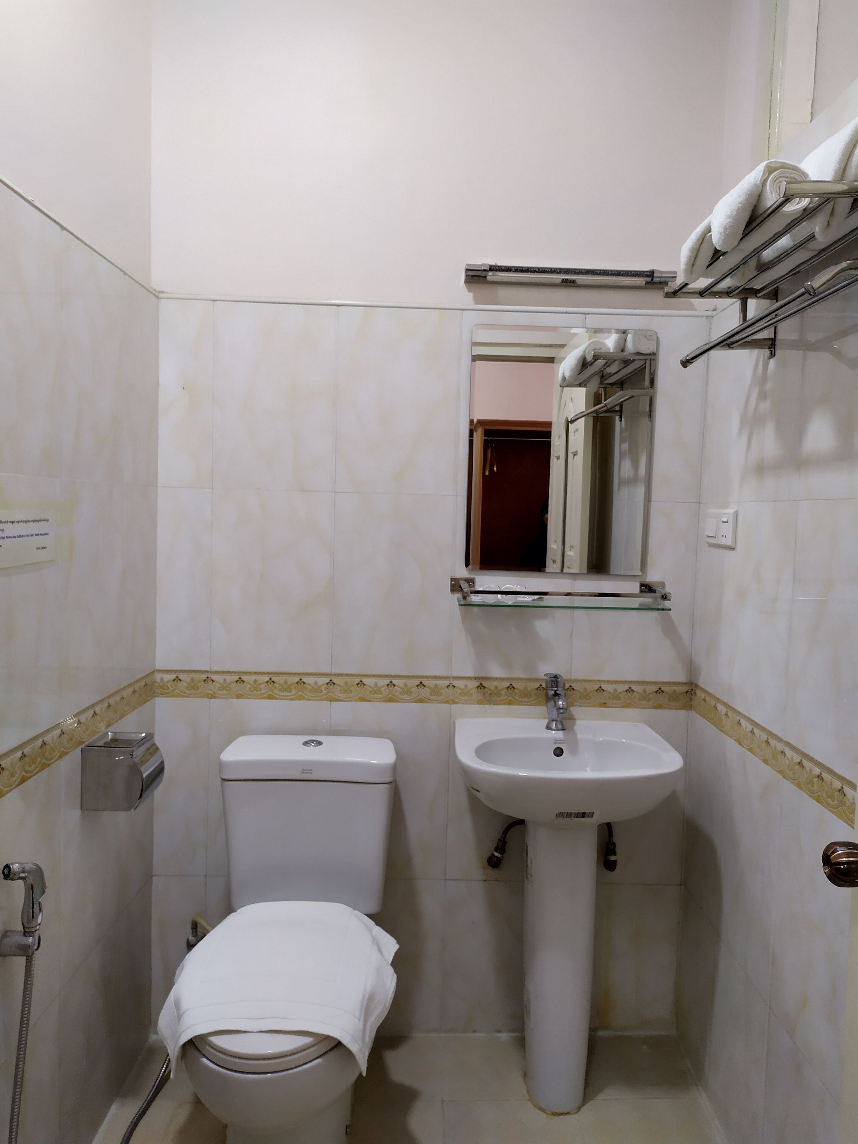 A small bathroom with a toilet, sink, and a mirror above the sink.