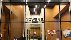 The entrance to a hotel named 'TOWER B' with a modern design, featuring glass doors and a reception area visible through the entrance. - MaxStays - Max Home at Da Men Residences (Subang Jaya)