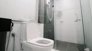 A modern bathroom with a toilet, a glass-enclosed shower, and a hand dryer. - MaxStays - Max Home at Da Men Residences (Subang Jaya)