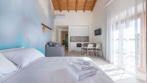 Ein Schlafzimmer mit Bett, Schreibtisch und einer kleinen Küchenzeile.