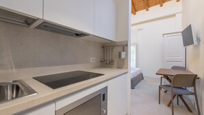 Une cuisine compacte équipée d’une cuisinière intégrée, d’un évier et d’un petit coin repas avec une table et des chaises.