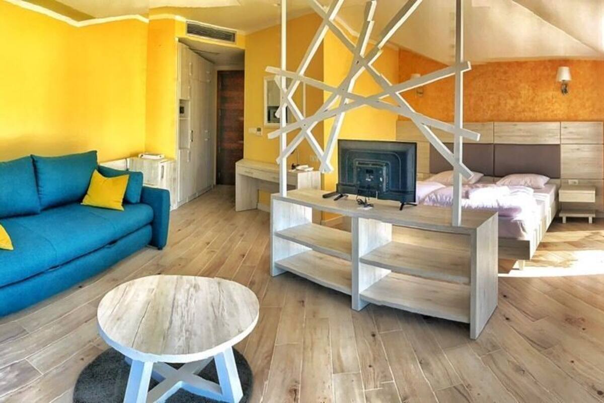 A modern living room with a blue sofa, a round coffee table, and a yellow armchair.