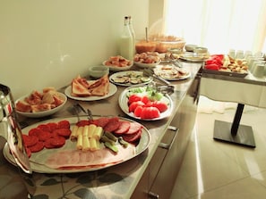 A buffet table with various food items including meats, cheeses, and vegetables. - Hotel Pierina (Budva)