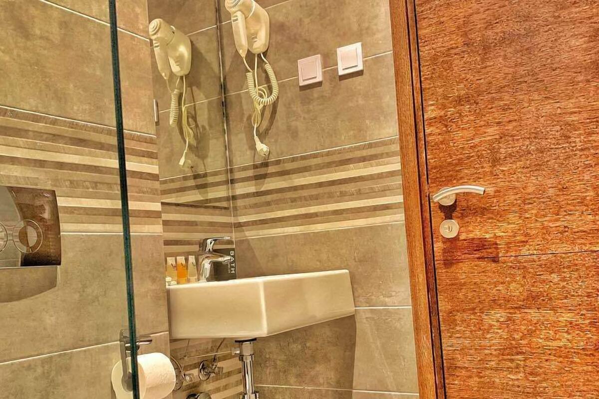 A modern bathroom with a glass shower enclosure, a toilet, and a sink.