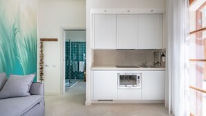 Uma cozinha moderna com armários brancos, forno embutido e pia.