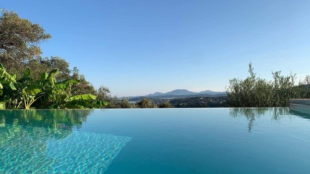A clear blue infinity pool with a view of distant mountains and a clear sky. - PRESTIGE VILLAS 'Tree Tops' - North East Coast Villa with infinity pool... (Agios Markos, Corfu)