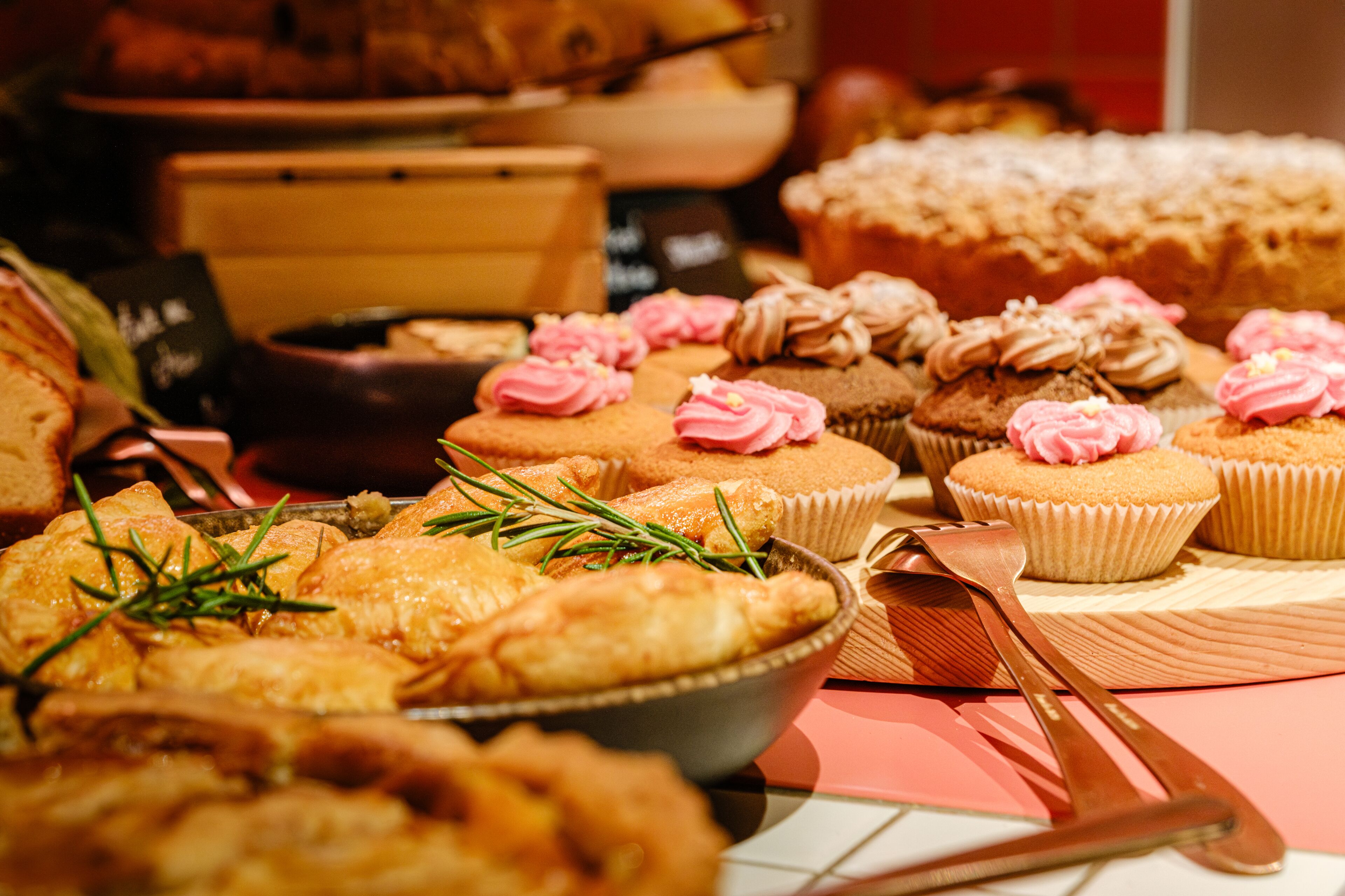 A variety of pastries and baked goods, including cupcakes and pastries, arranged on a table.