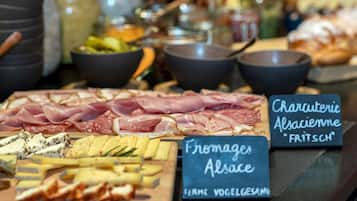 A charcuterie board with various meats and cheeses, accompanied by bowls of dips and condiments.
