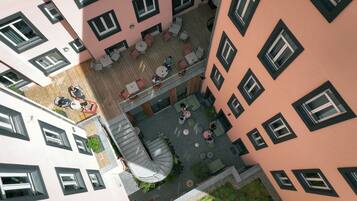 A multi-level outdoor courtyard with seating areas and a spiral staircase.