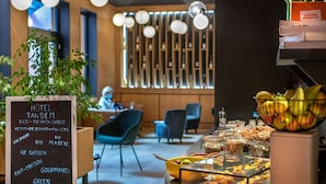 A hotel lobby with a signboard, seating area, and a buffet table.