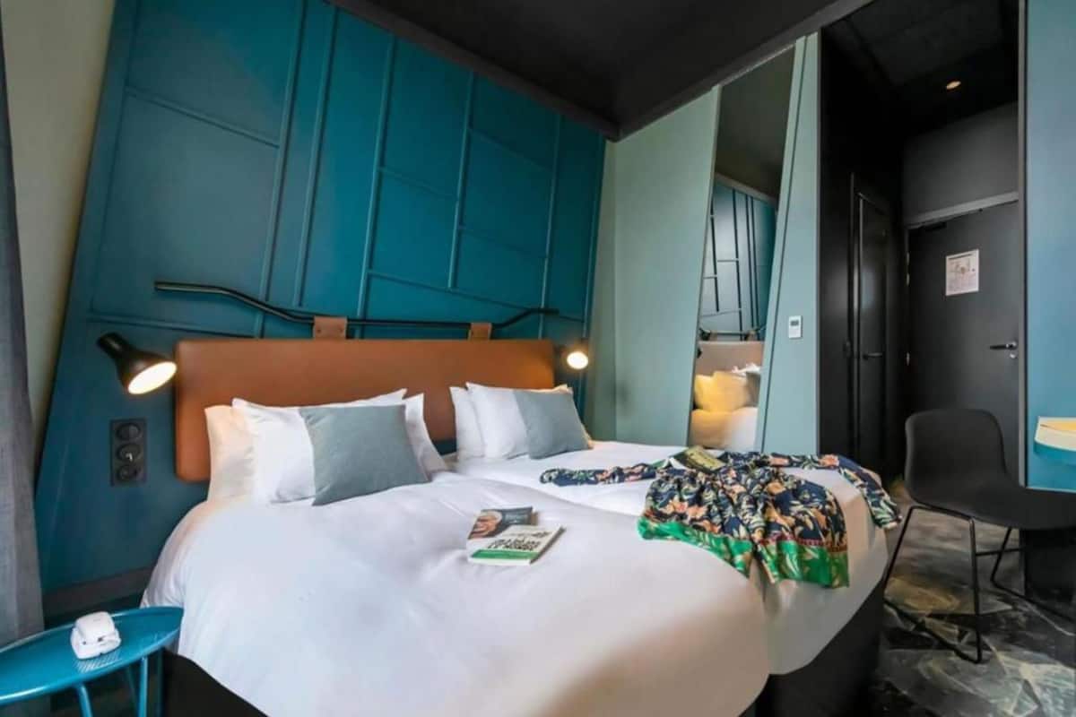 A hotel room with a large bed, a desk, and a chair.