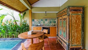 Una cucina con zoccolo in piastrelle, un armadietto in legno e un'area pranzo con tavolo e sedie.