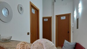 Una habitación con encimera de mármol, dos puertas de madera, una silla roja y un cuenco.