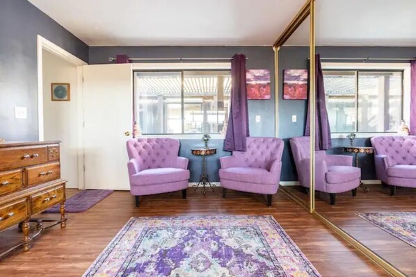 A room with a large mirror, purple armchairs, a wooden dresser, and a patterned rug. - Large country home with 3 bed rooms and 3 baths. (Lone Pine)