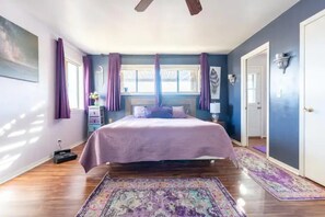A bedroom with a bed, purple curtains, a ceiling fan, and a colorful rug. - Large country home with 3 bed rooms and 3 baths. (Lone Pine)
