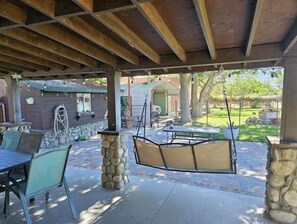 An outdoor patio area with stone pillars, metal tables, and chairs. - Large country home with 3 bed rooms and 3 baths. (Lone Pine)