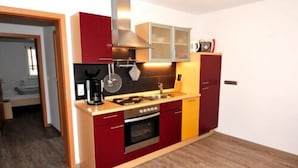A compact kitchen with a stove, oven, and microwave. - Ferienwohnungen am Sonnenplatz (Rust)
