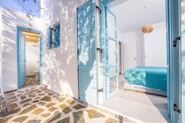 A room with a bed, a door, and a window.