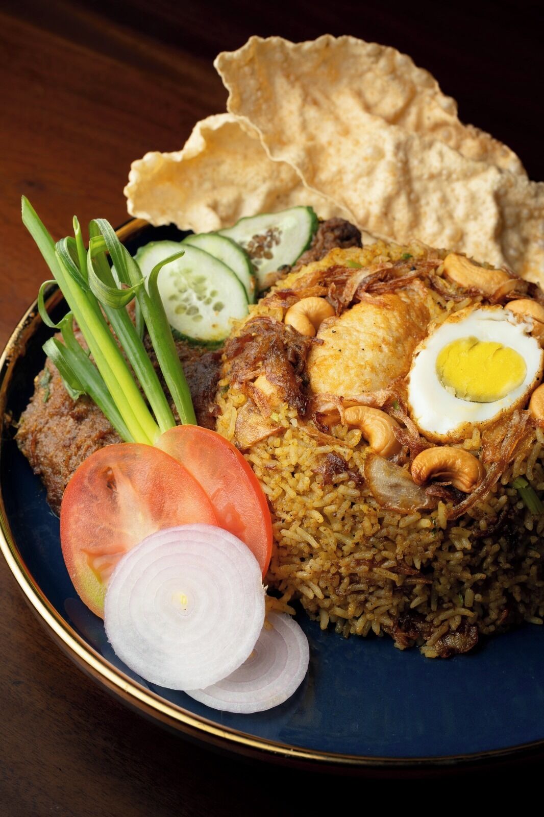 A plate of fried rice with vegetables and a boiled egg.