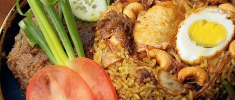 A plate of fried rice with vegetables and a boiled egg.