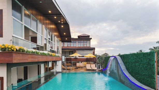 A swimming pool with a slide, lounge chairs, and umbrellas. - Beach Corridor Hotel & Spa with Free Airport Shuttle (Negombo)