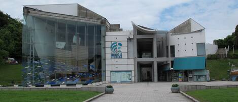 A modern building with a glass facade and a logo on the side.
