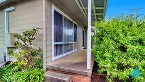 A house with a covered porch, large windows, and a brick foundation. - Driftwood in Blacksmiths - free WIFI, close to the beach (Blacksmiths)